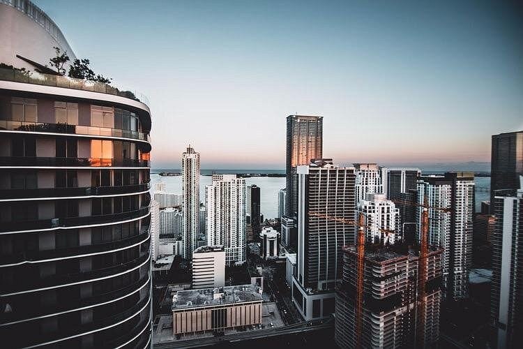 Brickell's towers from above at dusk, the bay grey-blue beyond them